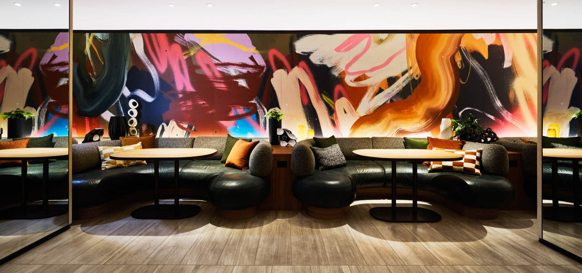 Modern interior design with abstract wall paper by Rowena Martinich and black leather furniture.