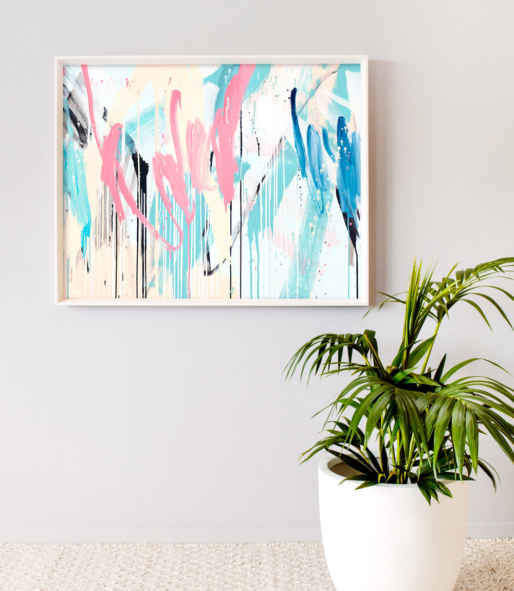 A limited edition print featuring abstract colors on a wall, with a potted plant to the side.